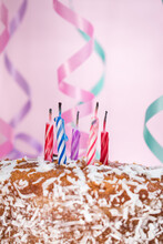 Some Birthday Candles On A Cake And Some Birthday Stuff With A Pink Background 