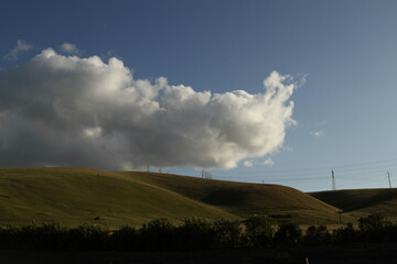 Sticker - Beautiful view of hills with electric lines under a blue sky with fluffy clouds in California