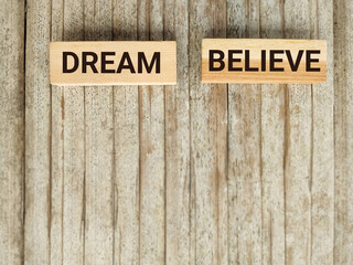Wall Mural - Inspirational and Motivational Concept - DREAM BELIEVE text background. Stock photo.