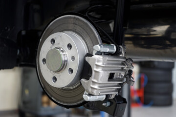 Wall Mural - Brake disc and brake caliper installed on a modern car. Selected focus. The background is blurred.