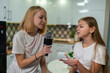 © Olleg1 - two teenage girls singing microphone at home fun.