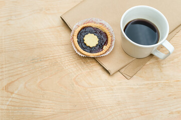 Canvas Print - delicious jam short crust pastry and black coffee cup on a food paper and rustic wood tabletop