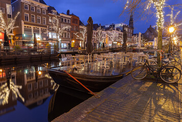 Wall Mural - Beautiful old houses and illumination on the Leiden city embankment at sunset.