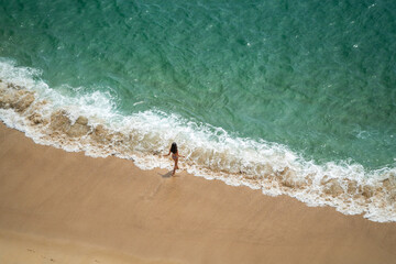 Wall Mural - Europe, Portugal, Nazare. Girl in surf on beach