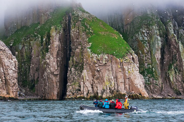 Canvas Print - Tourists on zodiac reaching the island, Cape Archen, Bering Sea, Russian Far East