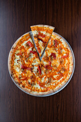 Wall Mural - Vertical top view of a sliced spicy pizza