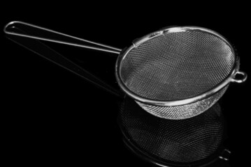 Canvas Print - Closeup shot of a sieve on a dark background