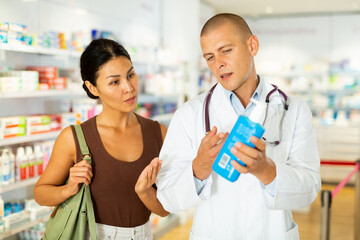 Female buyer consults the pharmacist which lotion or ointment to buy at the pharmacy