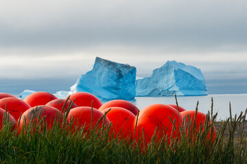 Poster - Red buoys on the beach with floating iceberg in the fjord, Qeqertarsuaq, Greenland