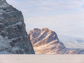 Poster - Icebergs frozen into the sea ice of the Uummannaq fjord system during winter, Uummannaq Island in the background. Greenland, Danish Territory