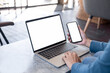 © panitan - computer screen,cell phone blank mockup.hand woman work using laptop texting mobile.white background for advertising,contact business search information on desk in cafe.marketing,design