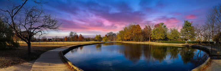 Wall Mural - a stunning panoramic shot of the blue waters of the lake in the park surrounded by gorgeous autumn colored trees reflecting off the lake at sunset at Centennial Park in Nashville Tennessee USA