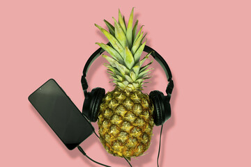 Poster - Pineapple with headphones connected to a smartphone on a pink background