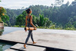 © Sergei - Girl with yoga mat with tropical look.