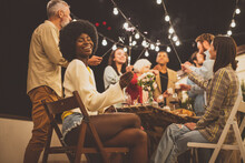 Family And Friends Celebrating At Dinner On A Rooftop Terrace. Storytelling Footage Of A Multiethnic Group Of People Dining On A Rooftop. Family And Friends Make A Reunion At Home