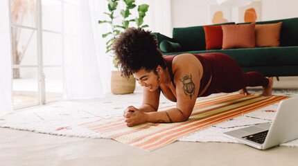 Wall Mural - Healthy woman holding plank position at home