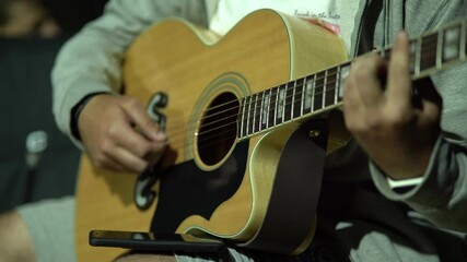 Sticker - Closeup on the male hands playing guitar at night outdoors - 4K