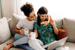 © (JLco) Julia Amaral - Happy lesbian couple video calling their friends at home