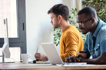 Fototapete - Two concentrated graphic designer working with computer in modern startup office.