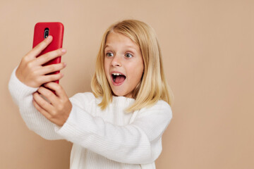 Wall Mural - Positive little girl with blond hair on a beige background