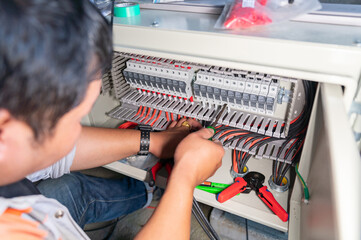 The engineer is connecting the power from the solar panel to the fuse set .