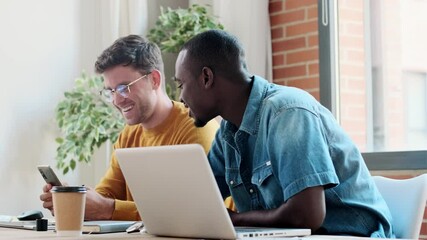 Fototapete - Video of two graphic designer working with laptop while celebrating something shaking hands in modern startup office.