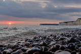 Fototapeta Tulipany - Sunset over the Seven Sisters chalk cliffs coastline, East Sussex. Low angle view.