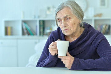 Sticker - Portrait of a sad old woman drinking tea