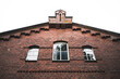 view to the sky on a brick stone building with details and withe window frames 