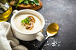 Mushroom Soup on dark stone table. Healthy vegan dish. Autumn or winter soup.