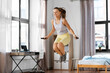 fitness, sport and healthy lifestyle concept - happy smiling teenage girl skipping with jump rope at home