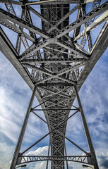 Poster - Vertical shot of a big metal bridge on a cloudy sky background