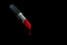 Red Lipstick On A Black Background, Melting And Dripping. Close-up.