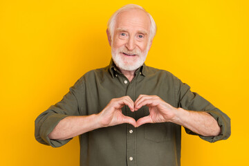 Poster - Photo of cheerful candid aged person hands fingers make heart symbol isolated on yellow color background