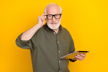 Sticker - Portrait of candid friendly aged person hand touch eyewear look camera isolated on yellow color background