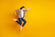 © Tetiana - Full size profile side photo of young lady jump fly look empty space help superhero isolated over yellow color background