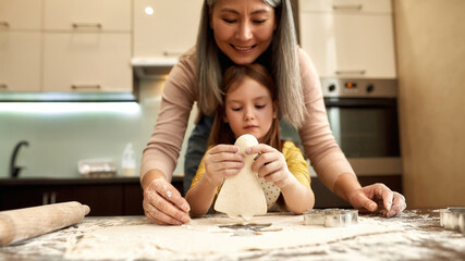 Little girl holding dough in human form for cookie