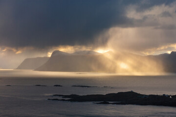 Canvas Print - Sunbeams over rocky coastline in sunset