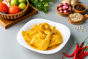 Wall Mural - Indonesian Traditional cuisine : Ayam Gulai Padang. Ayam Gulai is a popular dish of chicken curry from Padang, West Sumatra. served on plate and isolated on gray background.