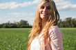 Attractive Argentinian woman walking on an agricultural field under a bright sunny sky
