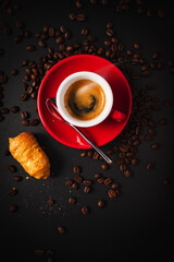 Canvas Print - Vertical shot of  a cup of coffee with roasted beans and bread on a dark surface