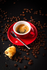 Poster - Vertical shot of  a cup of coffee with roasted beans and bread on a dark surface