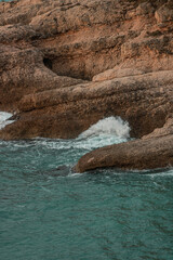 Sticker - Sea waves rolling and crashing on the rocks with a splash during the daytime