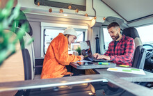 Young Woman And Man Telecommuting During A Camper Van Trip