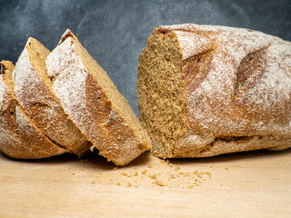 Sliced loaf of black bread on a kitchen board. Bread on a black background. Healthy food.