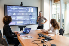 Project Manager Conducting Team Meeting With Digital Screen