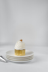 Sticker - Cupcake on a plate, cupcake with white frosting in gold cupcake liners, gold star on cupcake