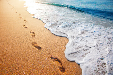 Wall Mural - beach, wave and footprints at sunset time