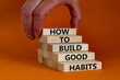 Build good habits symbol. Wooden blocks on beautiful orange background, copy space. Words 'How to build good habits'. Businessman hand. Build good habits concept. Copy space.