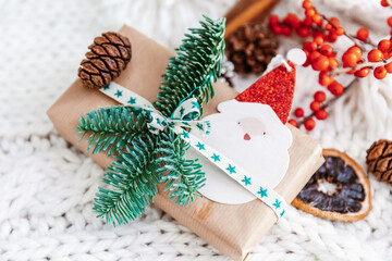 Canvas Print - Christmas background with gift box and Christmas decorations on cozy knitted background. Flat lay, top view and copy space for text